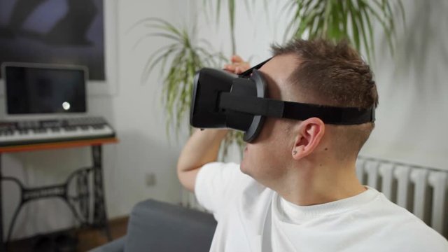 man in white shirt taking of vr at home virtual reality googles 

