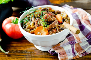 Beef stew with vegetables in a bowl on a wooden table