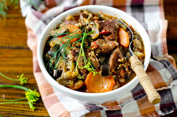 Beef stew with vegetables in a bowl on a wooden table