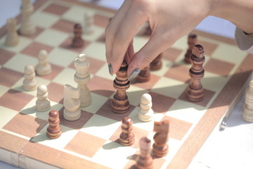 brown chess board close up with a hand