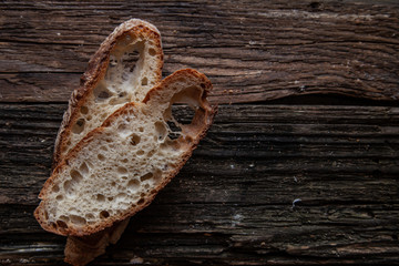 Fresh bread slice and cutting knife on rustic table