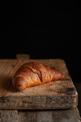 Croissant with chocolate  on the wooden tray with free space