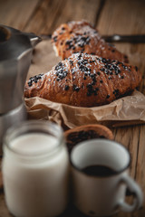 Croissant with chocolate and coffee on the wooden table