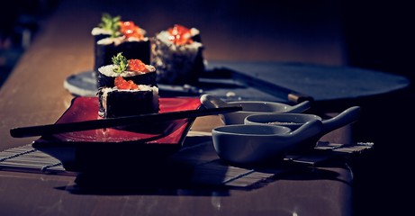 Sushi on a servery plate with accompaniment bowls