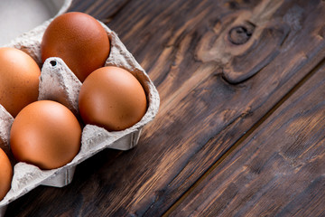 chicken eggs on old wooden board with blank space for text