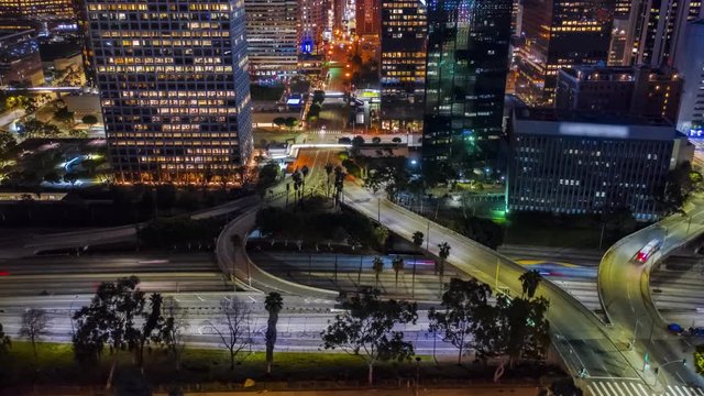 4K Cinematic Urban Aerial Hyperlapse ( timelapse in motion ) view on the busy city freeway traffic and high-rise buildings with glass walls.