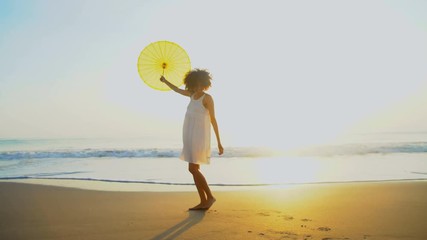 Portrait of attractive African American female dancing on beach on vacation