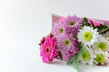 Flower bouquet in a pink wrap on white background copy space