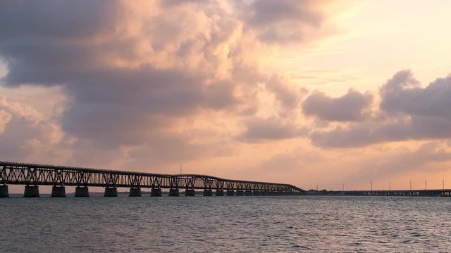 Panning view of Sunset orange clouds skyscape seascape in Bahia Honda State Park in Florida Keys with old railroad bridges ocean and gulf of mexico