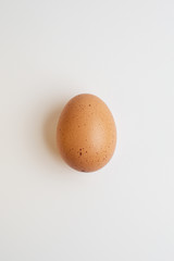  brown speckled eggs lie on a table on a white background