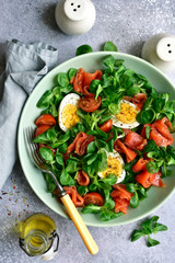 Green salad with salted salmon, tomato and boiled eggs.Top view with copy space.