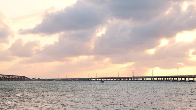 Sunset yellow clouds seascape in Bahia Honda State Park in Florida Keys with old railroad and seven mile bridge ocean and gulf of mexico with boat in water