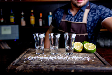 Tequila silver , alcohol in shot glasses, lime and salt, toned image, selective focus