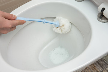 Washing inside the toilet bowl with a disinfectant