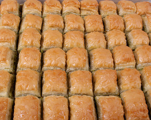 Baklava with walnut pistachios with large table trays and striped white stripes from the bottom