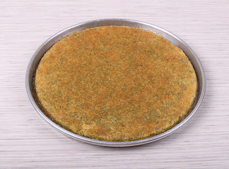 Baklava Kadayev with walnut pistachios with rounded trays on a large table and white striped