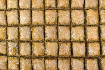 Baklava with walnut pistachios on a large table and white striped