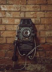 Old vintage telephone on the red brick wall