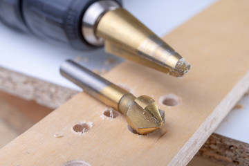 Obraz na płótnie Canvas Drilling and deepening holes in wood. Countersink and other accessories for small carpentry work.