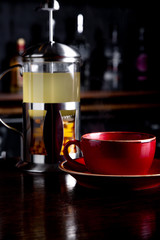Sea buckthorn tea in french press on a bar background at coffee shop.