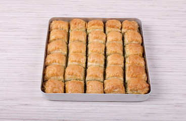 Baklava with green pistachios on white table