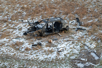 Wreck of a devastated car on a meadow. Disassembled car skeleton.
