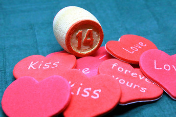 Wooden keg of lotto with the number 14 and hearts with inscriptions. Close-up. Background.