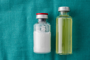 Vials of different size isolated on green cloth, conceptual image