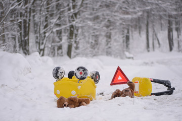 Death road accident in winter. Staging of an accident with teddy bears and a child's car. A photo with a strong emotional message. Dangerous driving.