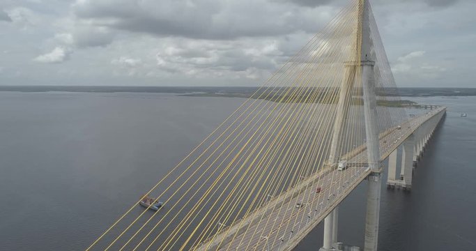 Low panning aerial revealing cars crossing the cable-stayed Rio Negro Bridge that links the cities of Manaus and Iranduba in the Brazilian Amazon