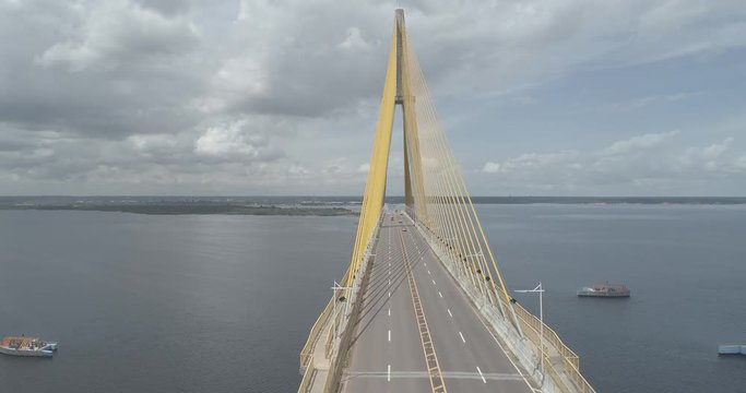 Aerial panning around the cable-stayed Rio Negro Bridge that links the cities of Manaus and Iranduba in the Brazilian Amazon with the sky, river and Manaus city in the background
