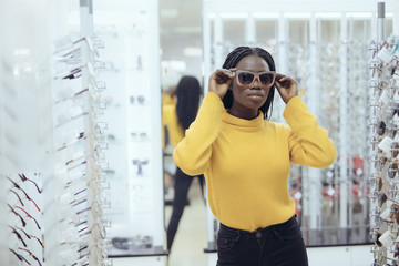 Young pretty african woman wear sunglasses in optical shop