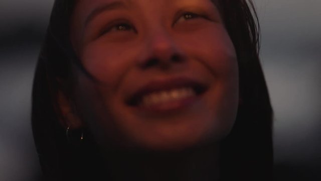 close up sparklers happy asian woman celebrating new years eve smiling enjoying independence day celebration on beach at sunset