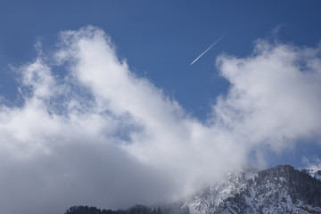 Airplane high in the Clouds over the Mountains