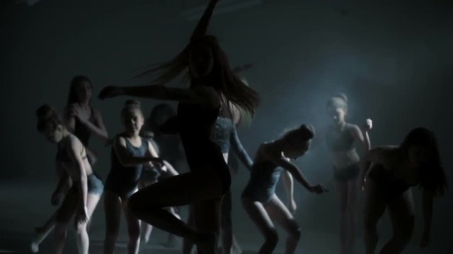 Silhouette of freestyle dancing girls using powder in dance moves