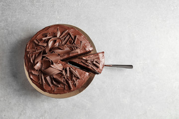 Tasty homemade chocolate cake and shovel with piece on table, top view. Space for text