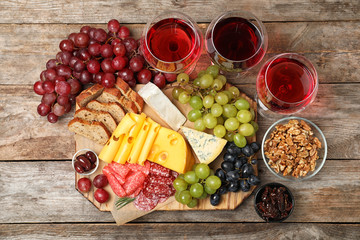 Flat lay composition with wine and snacks on wooden background