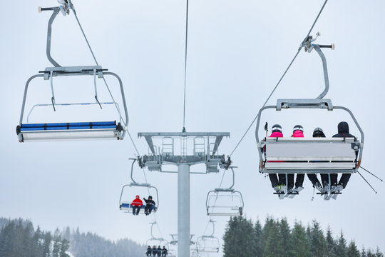 Chairlift with people at ski resort. Winter vacation
