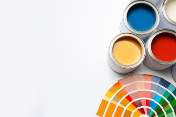 Different paint cans and color palette on white background, top view. Space for text
