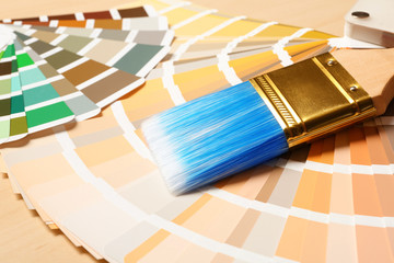 Paint brush and color palettes on table, closeup