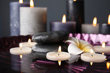 Spa composition with burning candles and water in plate