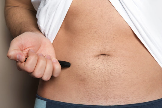 Man doing insulin injection in stomach, closeup. Diabetes disease
