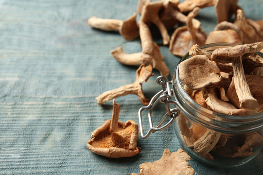 Composition of dried mushrooms and glass jar on table, closeup. Space for text