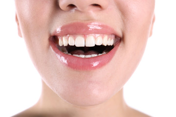 Young woman with healthy teeth smiling on white background, closeup