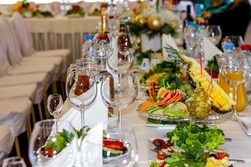 Served dishes to the table for holiday. Cutlery and food on white tablecloths in the restaurant. Design a festive Banquet. Luxurious food for guests and visitors.