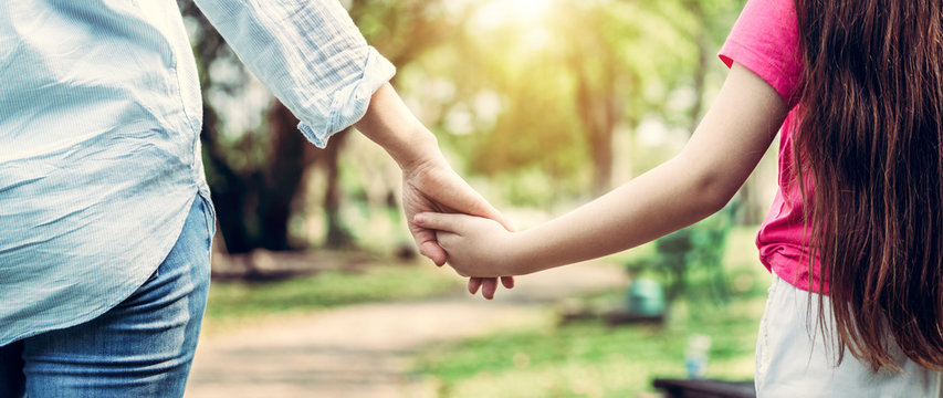 Relaxed happy mother and little kid daughter in outdoors public park. Parenthood and child concept.