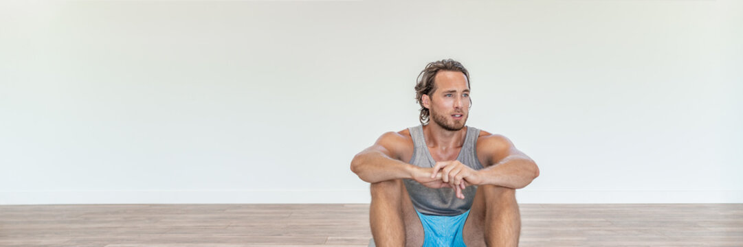 Fit man living active healthy lifestyle taking a break from gym workout training at home tired sweating. Portrait banner panorama.