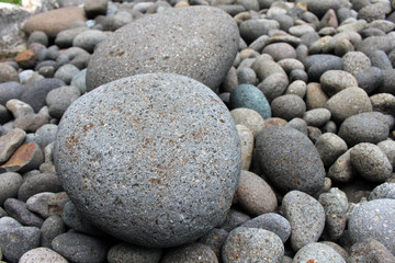 Fototapeta na wymiar Big stones among smaller pebbles, in the garden