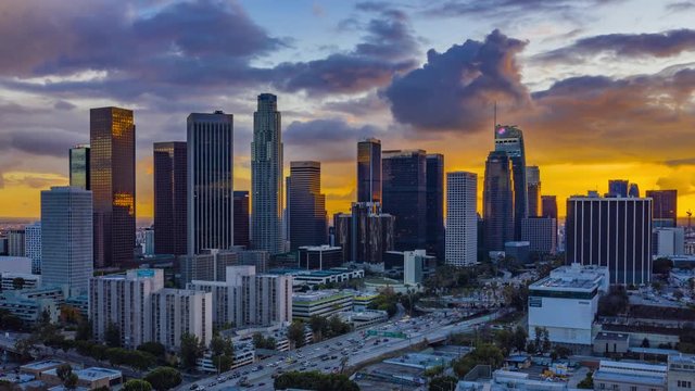 4k aerial timelapse in motion ( hyperlapse ) cinematic view of Los Angeles downtown’s skyscrapers with stunning sunset with rain clouds in the background