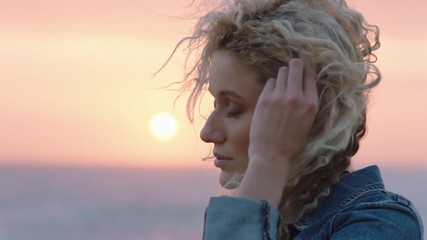 portrait of beautiful woman enjoying peaceful seaside at sunset contemplating journey exploring spirituality feeling freedom with wind blowing hair